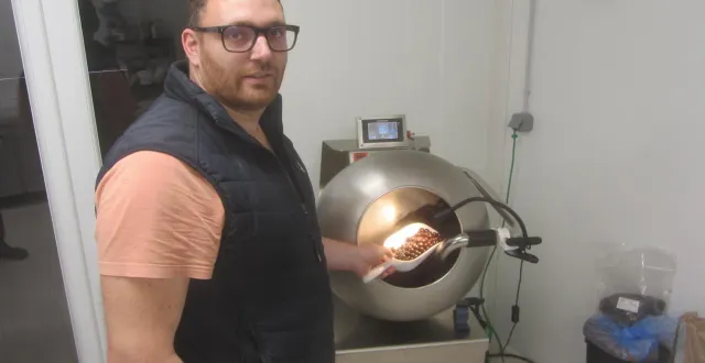 photo  flavien bondu devant sa turbine d’enrobage de chocolat, montre l’un des résultats de son travail.  &copy;  ouest-france 