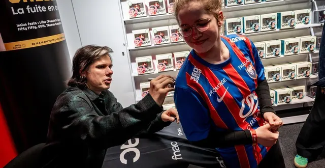 photo  en dédicace à la fnac de caen, orelsan signe un maillot du stade malherbe caen, au lendemain de son 