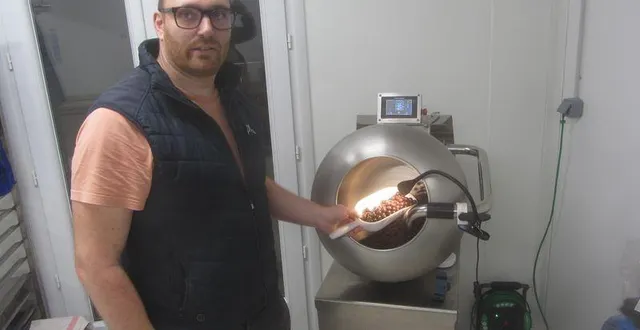 photo  devant sa turbine d’enrobage de chocolat, flavien bondu présente le fruit de son travail.  &copy;  co 