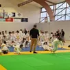 photo  un bénévole guide les jeunes judokas lors de l’échauffement. 