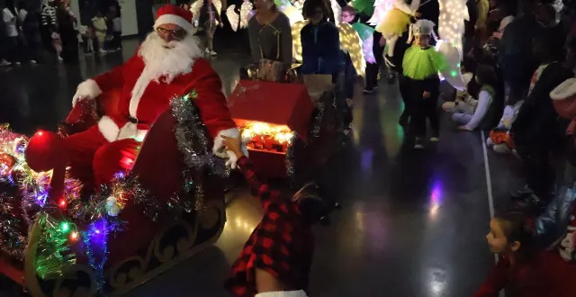photo  le père noël est arrivé en traîneau entouré par des anges aux ailes lumineuses, dans une salle madeleine-marie plongée dans l’obscurité pour faire plus d’effet, mercredi 10 décembre 2025, pour le noël des familles, à sablé-sur-sarthe.  &copy;  ouest-france 