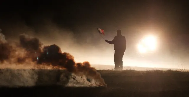 photo  un homme brandit un drapeau français au milieu des gaz lacrymogènes tirés par les forces anti-émeutes sur des agriculteurs, lors d’une manifestation de plus de 500 agriculteurs de la confédération paysanne et de la coordination rurale aux bordes-sur-arize, en ariège, le 11 décembre 2025.  &copy;  antoine berlioz / hans lucas via afp 
