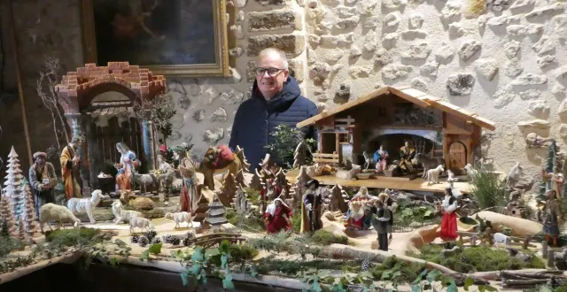 photo  jean-louis cerru, derrière trois crèches de bavière et un décor de pins avec des figurines étonnantes dont un dromadaire.  &copy;  ouest-france 