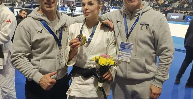 photo  pauline cuq, médaille d'or autour du cou, entre son père cédric, et anthony mortini, entraîneur du dan 79.  &copy;  dan 79 