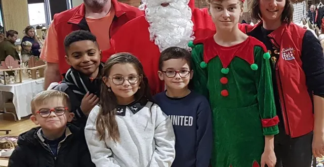 photo  syméon, solyne, marcel et jule posent fièrement aux côtés du père noël lors du marché de noël.  &copy;  le maine libre 