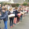 photo  dans la cour de leur école, les enfants ont fait la chaîne pour porter les boîtes de noël jusqu’aux véhicules chargés de les transporter. 