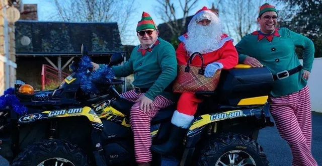 photo  arrivée festive en quad pour le père noël, accompagné de deux lutins.  &copy;  le maine libre 