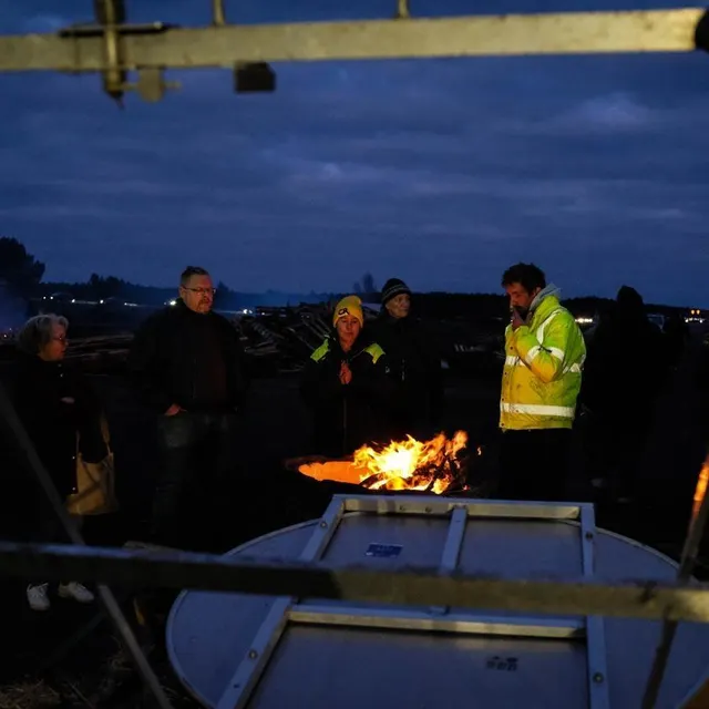 photo des agriculteurs mobilisés se réchauffent au coin d’un feu à cestas près de bordeaux sur l’a63, le soir du réveillon.  ©  thomas bernardi/afp