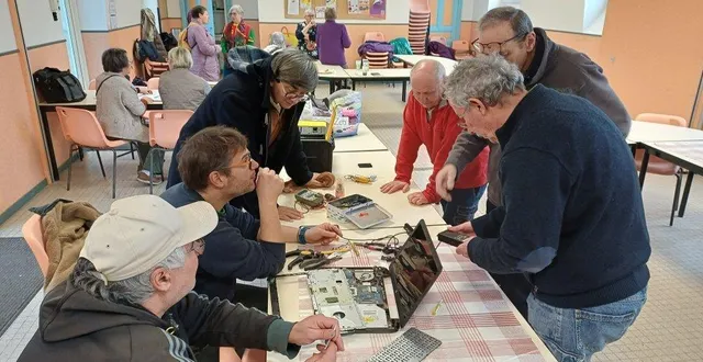 photo  denis, au centre à gauche, spécialiste en électricité, essaie de trouver la bonne solution pour réparer cet ordinateur, sous les conseils avisés des autres bénévoles.  &copy;  co 