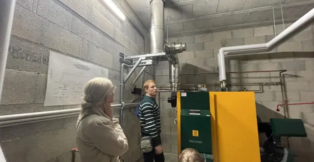 photo  le conseiller en énergie partagée olivier hennebert lors de l’inauguration (ici devant la chaudière à bois avec une enseignante et un élève).  &copy;  le maine libre 