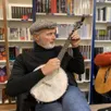 photo pierre bordage jouant du banjo à la librairie l’atalante, rue des vielles-douves, à nantes. une maison qui l’éditait dans son volet édition.