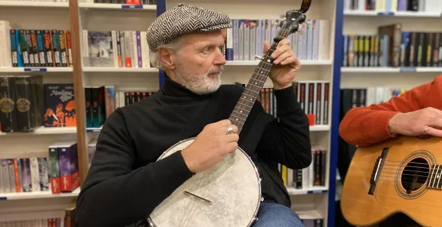 photo  pierre bordage jouant du banjo à la librairie l’atalante, rue des vielles-douves, à nantes. une maison qui l’éditait dans son volet édition.  &copy;  l’atalante 