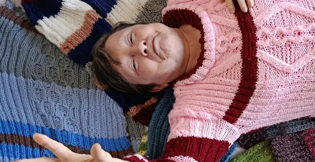 photo  nicole a revêtu son pull tricoté par ses soins et a accepté de s’allonger sur un matelas douillet fait à partir des pulls qu’elle tricote depuis février 2025 pour les sans-abri, en privilégiant des couleurs chatoyantes.  &copy;  le maine libre 