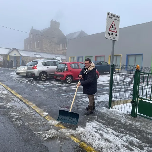 photo effectif réduit au collège de sourdeval, dans la manche, où seuls huit élèves sur trente sont présents. louis-rené de la perraudiere, professeur de mathématiques, dégage la neige du parking.  ©  ouest-france