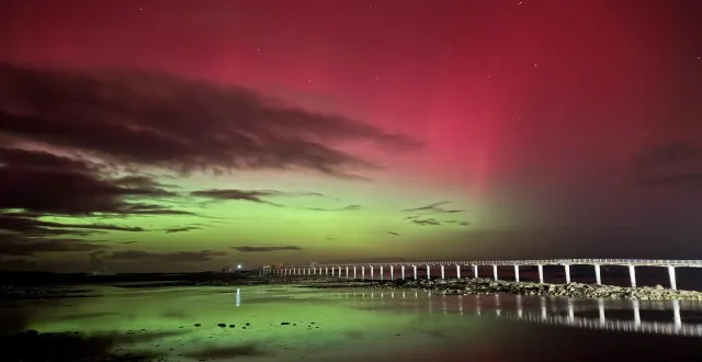 photo  l’estacade de roscoff en ligne de fuite, séparation entre le ciel coloré par les aurores boréales et leur reflet dans l’eau.  &copy;  justine nédélec 