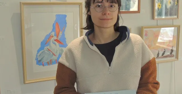 photo  gladys démurgé devant ses tableaux présente le livre qu’elle a illustré.  &copy;  ouest-france 