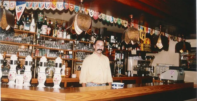 photo  didier benatre derrière son bar du café des vosges, orné des fanions de clubs amateurs du 49.  &copy;  photo d. b. 
