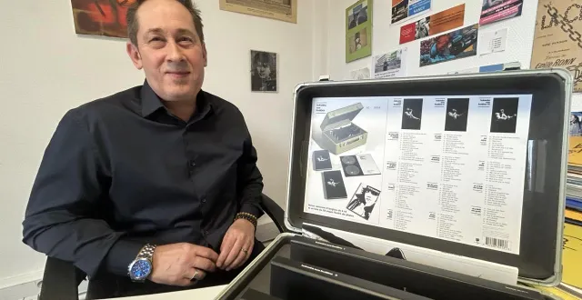 photo  jean-yves breteau, dans son bureau, avec une valise « balavoine sans frontières », qui contient une intégrale de 12 cd (127 titres remastérisés) et un livre de 32 pages sur le chanteur.  &copy;  le maine libre 