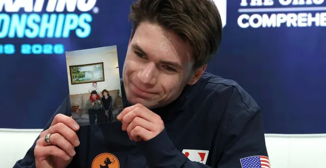 photo  maxim naumov avec la photo de ses parents lors de sa qualification pour les jeux olympiques.  &copy;  jamie squire / getty images via afp 