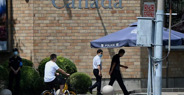 photo  des passants marchent devant l’ambassade du canada à pékin, le 10 août 2021.  &copy;  noel celis / afp 