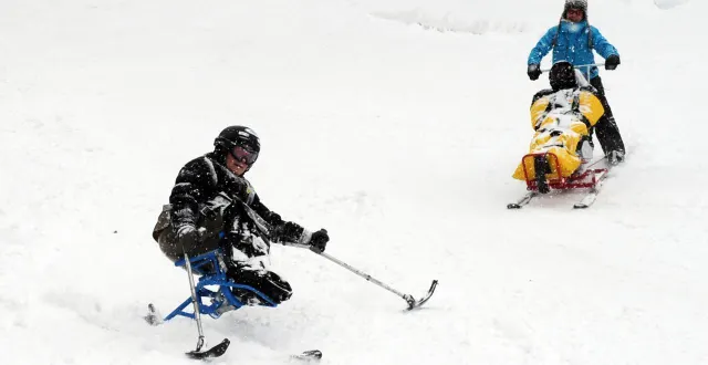 photo  une jeune femme paraplégique et un homme atteint de myopathie font du ski avec une monitrice spécialisée auprès des personnes en situation de handicap.  &copy;  jean-pierre clatot / afp 