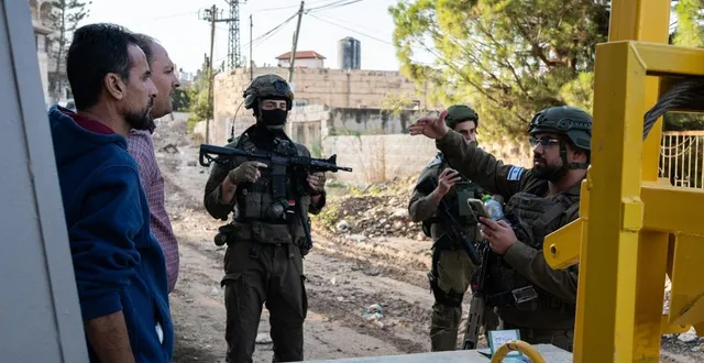 photo  le 27 novembre 2025, un soldat de l’armée d’occupation israélienne contrôle deux palestiniens à l’entrée du camp de réfugiés de jénine, en cisjordanie occupée.  &copy;  aruallan / hans lucas via afp 