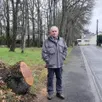 photo  gilles bodinier devant la souche de l’arbre qui s’est abattu dans sa rue. 