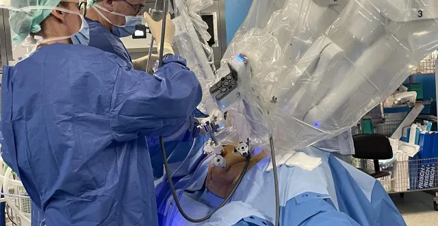 photo  le robot (à droite) est équipé. le chirurgien (au second plan) va rejoindre son poste de pilotage. l’adjointe responsable de bloc, ellen boussemaere, elle, reste à proximité pour changer et équiper les instruments.  &copy;  ouest-france 