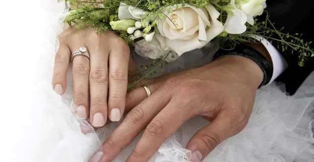 photo  gros plan sur les mains d’un couple de mariés tenant un bouquet de roses. photo d’illustration.  &copy;  archives getty images 