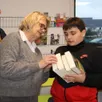 photo margaret, bénévole à la bibliothèque, explique à théo le retour des livres.