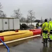 photo les employés des services techniques de la ville remplissent d’eau un barrage qui doit contenir la montée des eaux au port des noues.