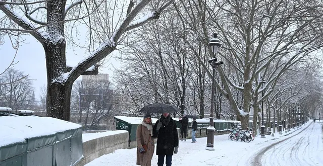 photo  des piétons marchent sur un trottoir enneigé après de fortes chutes de neige, à paris, le 7 janvier 2026.  &copy;  bertrand guay / afp 