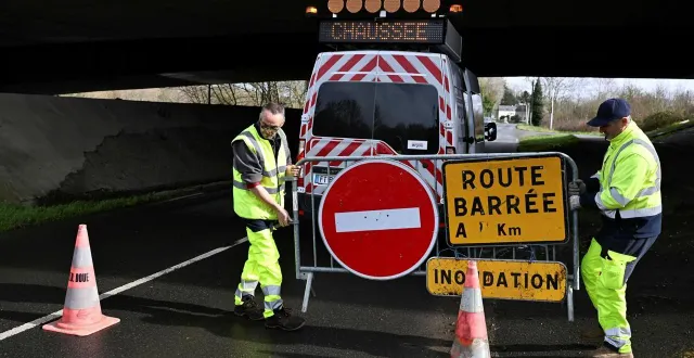 photo  des agents du maine-et-loire barrent la route entre les ponts-de-cé et juigné-sur-loire avant que la loire ne déborde sur la route.  &copy;  co - josselin clair 