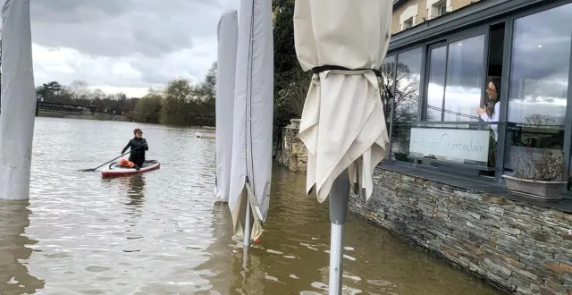 photo  bouchemaine, samedi 14 février 2026. à la pointe, à la confluence entre la maine et la loire, une serveuse de l’auberge de chanteclair est en pleine discussion avec une pagayeuse.  &copy;  loire attitude 
