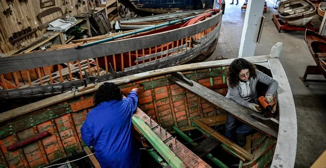 photo  bénédicte ganivet, infirmière à l’epsm de caen et malika, patiente à l’hôpital de jour d’équemauville, s’affairent sur la charpente de la lune dans le hangar de l’association bateaux de normandie.  &copy;  photo : martin roche / ouest-france 