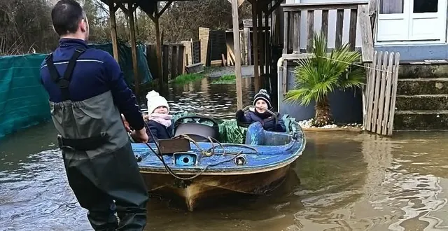 photo  à cheffes, un adulte tire le bateau pour permettre aux enfants de traverser les zones inondées en toute sécurité.  &copy;  co 
