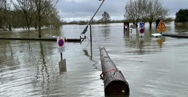photo  à écouflant les habitants découvrent des troncs géants dans leur jardin. les agents communaux les récupèrent avec des sangles et leur petite embarcation.  &copy;  ouest-france 
