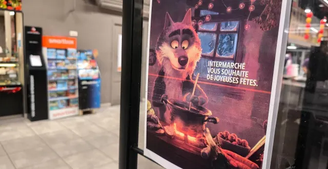 photo  une affiche avec le message « intermarché vous souhaite de joyeuses fêtes » et l’image du loup à la caisse d’un supermarché intermarché à valence, dans le département de la drôme, dans le sud-est de la france, le 21 décembre 2025.  &copy;  nicolas guyonnet / afp 