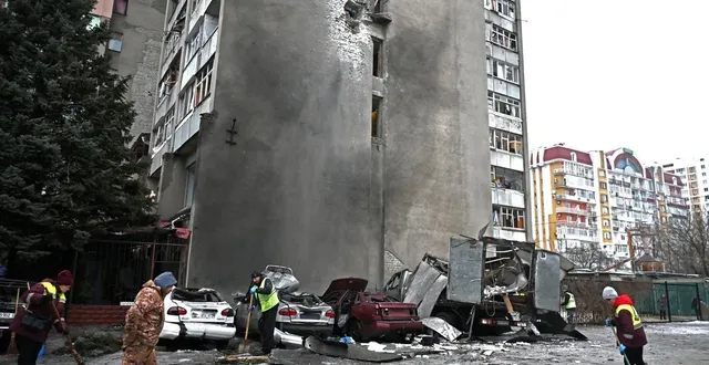 photo  des ouvriers municipaux dégagent les débris à côté de voitures détruites dans la cour d’un immeuble résidentiel, après une attaque aérienne à kharkiv, en ukraine, ce jeudi 26 février 2026.  &copy;  sergey bobok / afp 