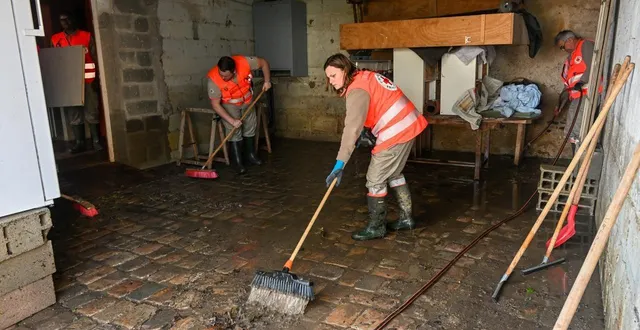 photo  armés de balais et raclettes, les bénévoles de la croix rouge dégagent le limon et la boue qui se sont déposés dans les habitations, après que l’eau se soit retirée.  &copy;  laurent combet 