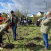 photo la maman de juliette, 8 mois et demi, est contente que les agents lui aient prêté un plantoir de vigne pour planter l’arbre de sa fille.