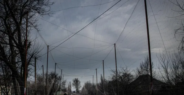 photo  une ukrainienne marche sous un filet anti-drones à droujkivka, dans la région de donetsk, le 24 février 2026.  &copy;  chris mcgrath / getty images via afp 