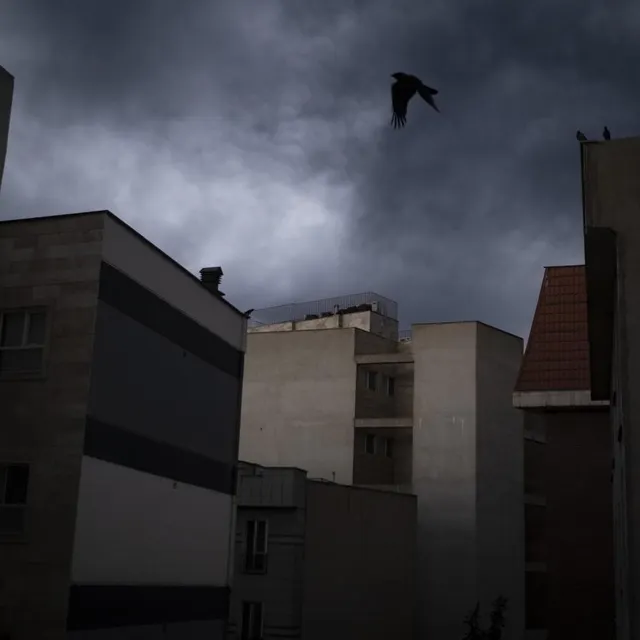 Vue d’une zone résidentielle alors que le ciel nuageux s’assombrit sous l’effet des résidus de suie provenant des installations de stockage de pétrole de Téhéran, touchées lors d’une campagne militaire américano-israélienne à Téhéran, en Iran, le 8 mars 2026. NurPhoto via AFP / MORTEZA NIKOUBAZL photo vue d’une zone résidentielle alors que le ciel nuageux s’assombrit sous l’effet des résidus de suie provenant des installations de stockage de pétrole de téhéran, touchées lors d’une campagne militaire américano-israélienne à téhéran, en iran, le 8 mars 2026. © nurphoto via afp / morteza nikoubazl