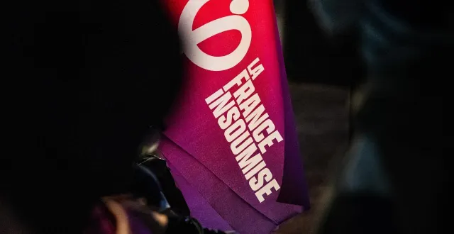 photo  un drapeau et logo de la france insoumise dans la foule au palais des congrès de perpignan le 1er mars 2026.  &copy;  jc milhet / hans lucas via afp 