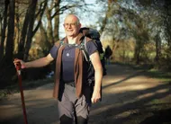 photo  dominique sempé, avec son bâton de pèlerin, une coquille saint-jacques et le sac qu’il a porté sur 2 408 km. 