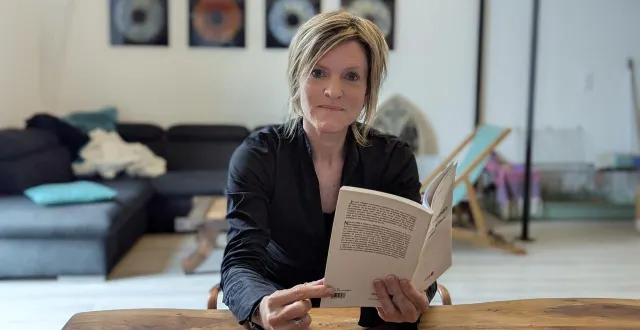 photo  karine houël tenant dans ses mains un recueil de la poétesse iranienne mahtab ghorbani.  &copy;  ouest-france 