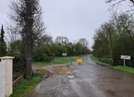 photo  des barrières interdisant l’accès sont installées au niveau de la rue des garennes à quelques dizaines de mètres de la route coupée. 