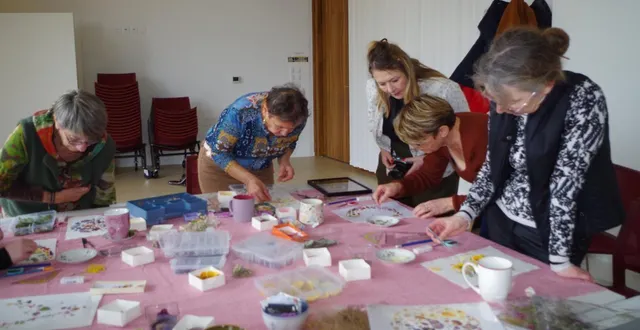 photo  patiemment, on choisit les fleurs et les feuilles pressées artisanalement, on les dispose sur le support avant de les coller.  &copy;  le maine libre 