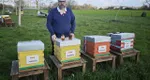 photo  Pierre Thollé avec deux des produits de ses ruches. Celles présentées sont parrainées par une entreprise. 
