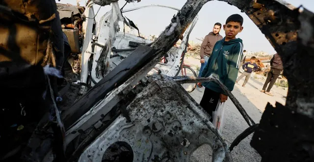 photo  des palestiniens inspectent le site d’une frappe aérienne israélienne visant un véhicule de police dans le centre de la bande de gaza, le 15 mars 2026.  &copy;  reuters 